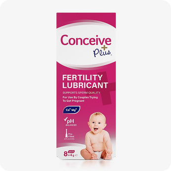 Conceive Plus Fertility Lubricant (8x4g Pre-filled Applicators) front-facing product box in pink and white design, featuring branding, product benefits like pH balance and sperm quality support, with a smiling baby image at bottom center of packaging.